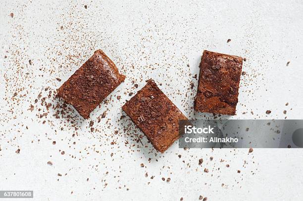 Three Pieces Of Brownie Topped With Chocolate Chips And Cocoa Stock Photo - Download Image Now
