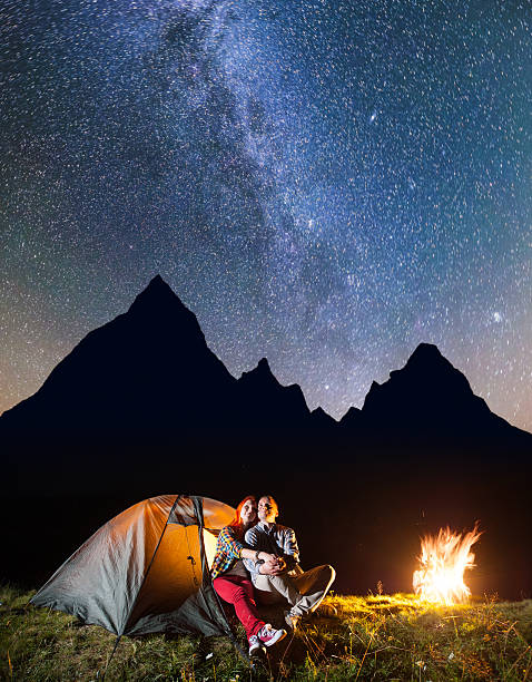 istock Tourists sitting near tent and campfire 637801616