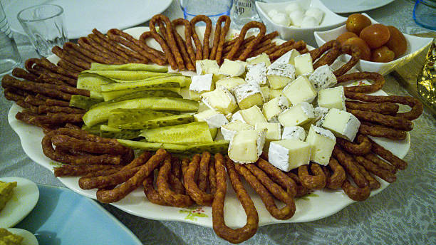 Plate with pickles, hermelin cheese and kabanos - sausage sticks Big platter of sliced pickles, hermelin cheese and kabanos - sausage sticks hermelin mustela erminea stoat stock pictures, royalty-free photos & images