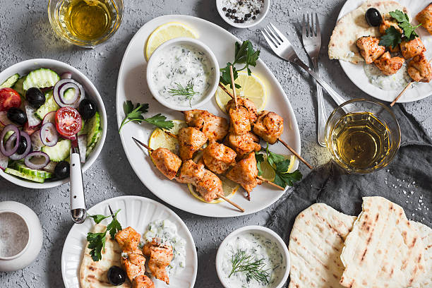 Yogurt marinated grilled chicken skewers with vegetables and tzatziki Yogurt marinated grilled chicken skewers with vegetables and tzatziki. Top view, flat lay greek food stock pictures, royalty-free photos & images