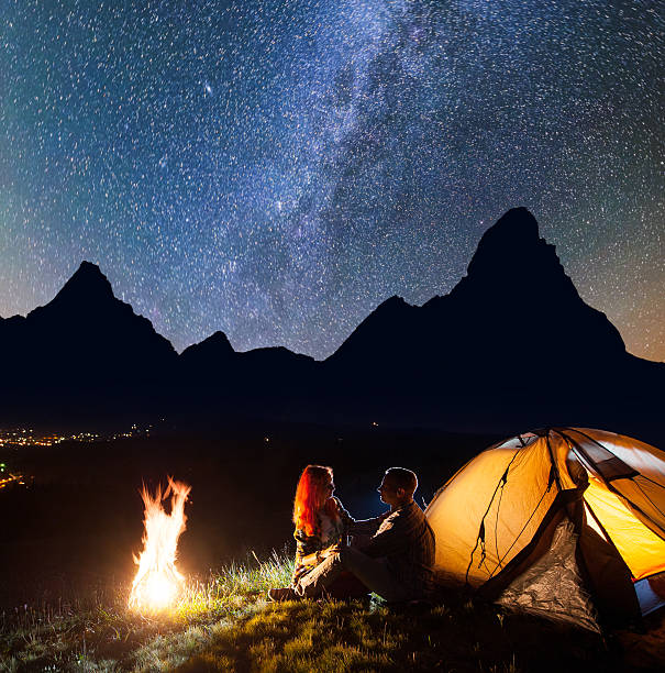 istock Tourists sitting face to face in front tent near campfire 637804232