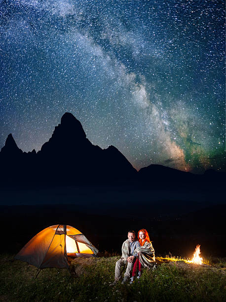 istock Happy couple hikers covered with a plaid sitting together 637804458