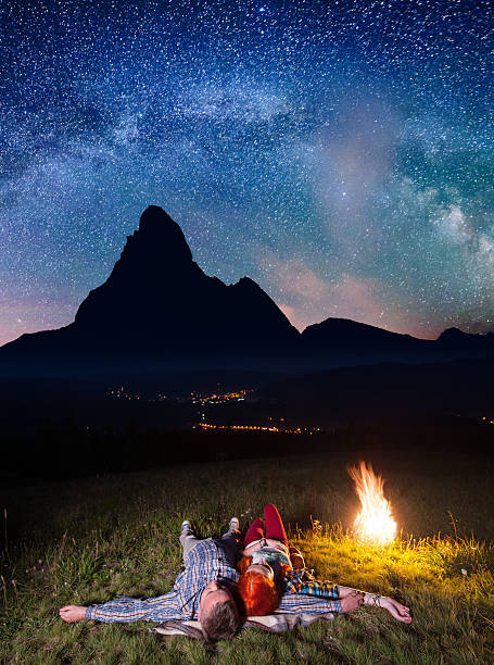 Happy couple hikers admiring the bright stars