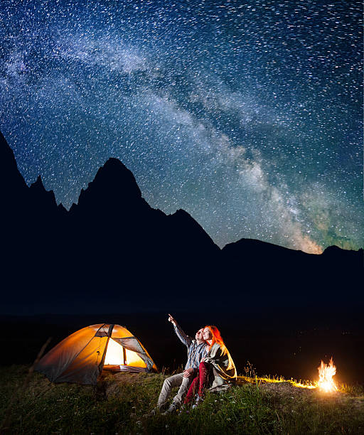 istock Couple sitting near the lighting tent and campfire 637807428