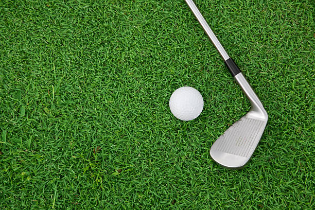 istock iron golf club and ball on a green grass 637808798