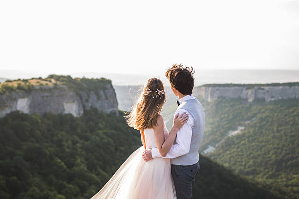 istock Bride and groom looking silhouettes of mountains 637810814