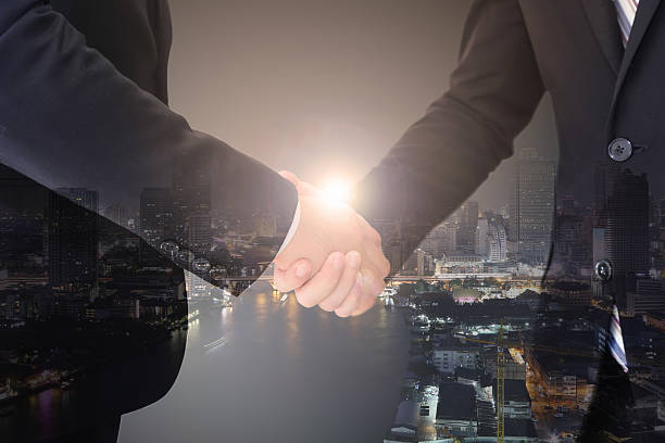 istock Businessman having a handshake over the city sunlight background 637813638