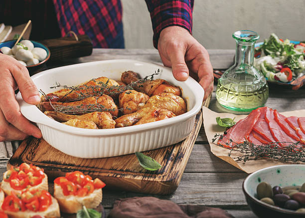 istock Male hands hold the dish with baked chicken legs 637814052