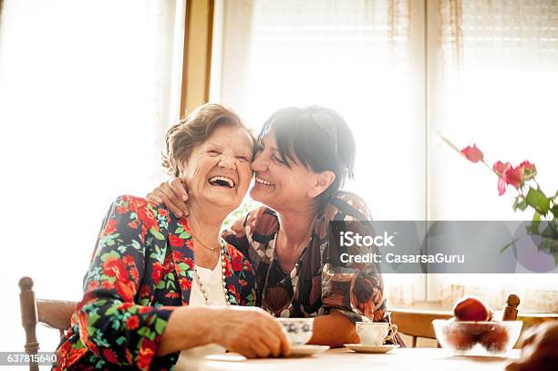 Senior Woman Relaxing With Her Daughter At Home Stock Photo - Download Image Now - Senior Adult, Mother, Care