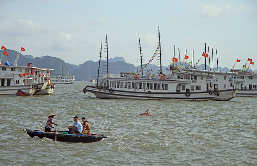 Ha Long Bay, Vietnam - June 3, 2015: people are floating in boat by Ha Long bay, Vietnam