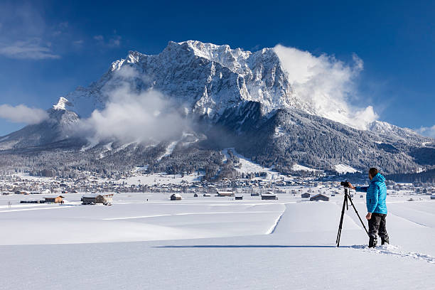 nature photographer at winter in front of mount zugspitze - zugspitze mountain tirol lermoos ehrwald imagens e fotografias de stock