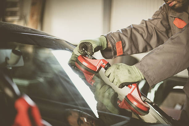 Mechanic changing glass on car.