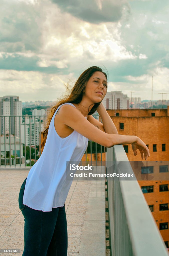 Girl on a Terrace Girl on a terrace with a urban landscape in the background Adult Stock Photo