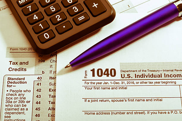 istock Pen and calculator on tax form 637821590