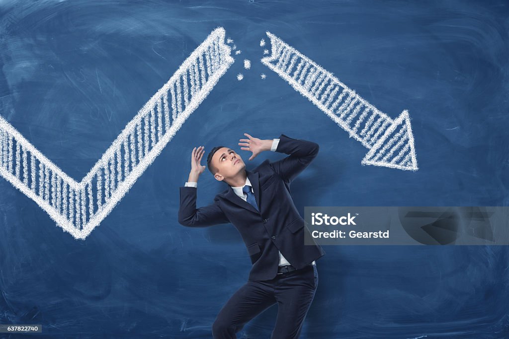 Geschäftsmann kauert auf blauem Tafelhintergrund mit Kreidezeichnung von - Lizenzfrei Geschäftsleben Stock-Foto
