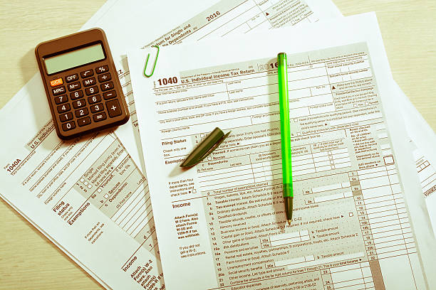 istock Green pen and calculator on tax form 637824584