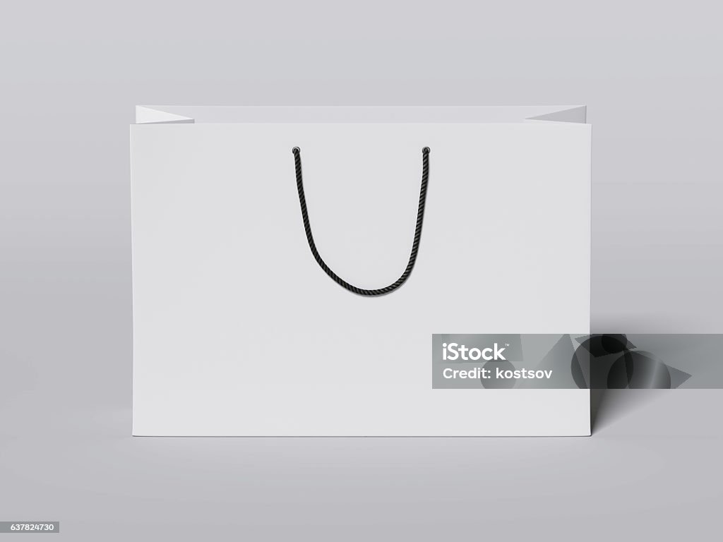 White shopping bag with black handles. 3d rendering White shopping bag with black handles on gray floor. 3d rendering Bag Stock Photo