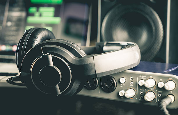 Close-up of sound mixing board with headphones on it for musical producer in studio