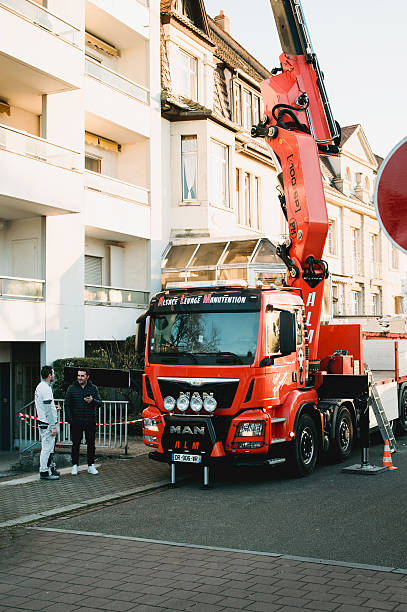 ciężarówka boom działa w pobliżu budynku - crane mobile crane derrick crane construction vehicle zdjęcia i obrazy z banku zdjęć