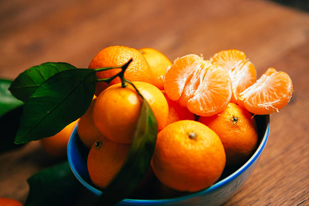istock many fresh mandarin oranges in  blue bowl, standing on a 637827222