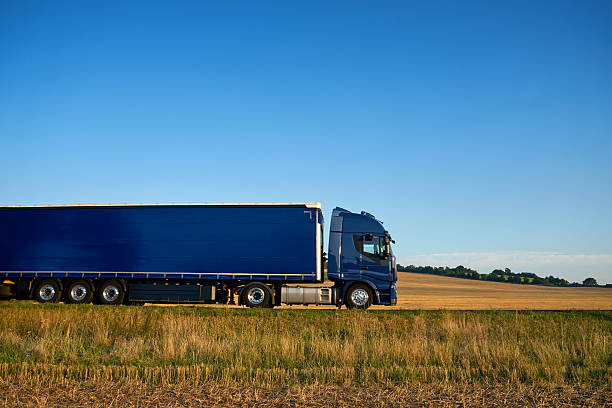 istock Blue truck traveling on a highway horizon along farm fields 637831202