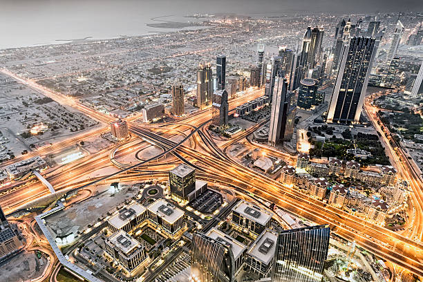 High-angle view of a busy urban highway surrounded by modern skyscrapers and residential buildings, capturing the dynamic city life and infrastructure.