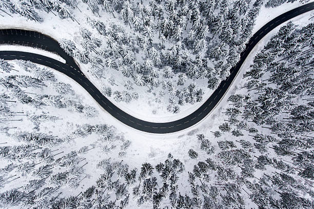 istock Road through the wintery forest - aerial view 637841004