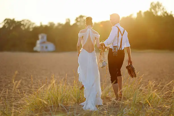 Photo of Bride and groom on a beach at sunset