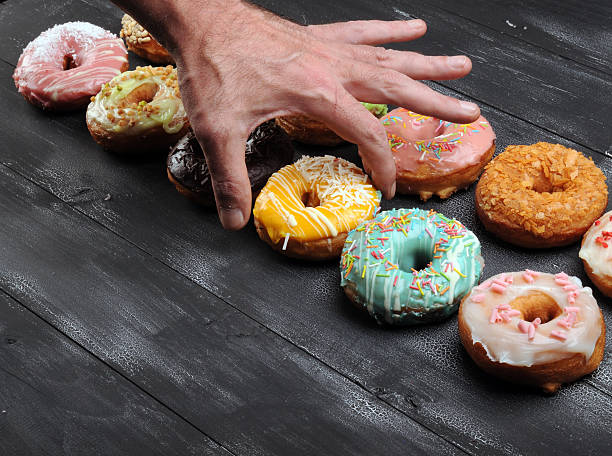 istock Fresh  donuts in soft colorful glaze on  black  wooden background 637848034