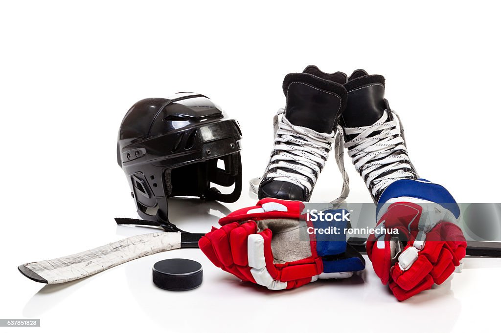 Ice Hockey Equipment Isolated on White Background Ice hockey equipment featuring safety helmet, pair of skates, gloves, stick and a hockey puck. Isolated on white background. Equipment Stock Photo