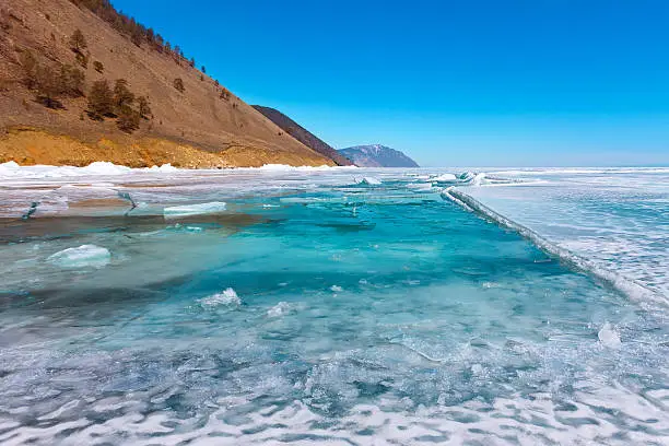 Growers ice iceberg in turquoise water of Lake Baikal.