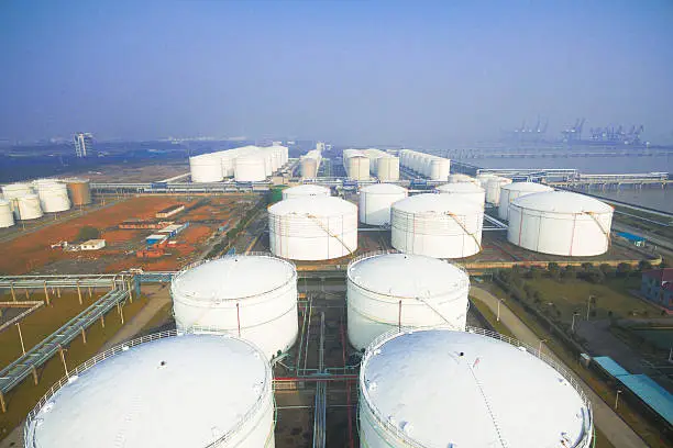 Photo of oil containers in modern refinery plant in blue sky