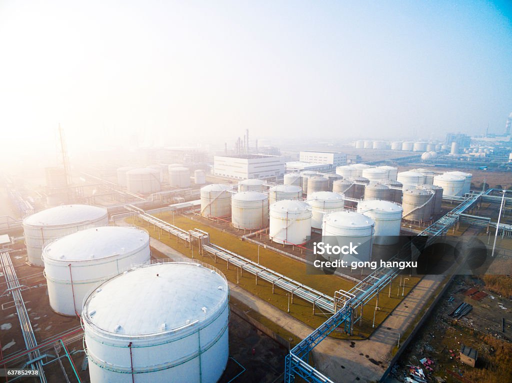oil containers in modern refinery plant in blue sky top view of white oil tank in modern refinery plant in blue sky Crude Oil Stock Photo