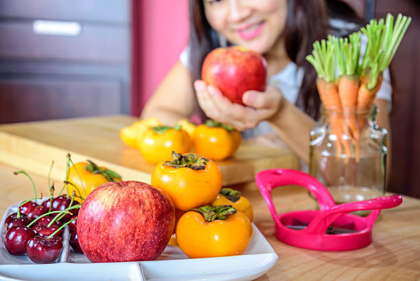 istock Woman's hand holding apple in modern kitchen/ healthy lifestyle conceptual 637853380