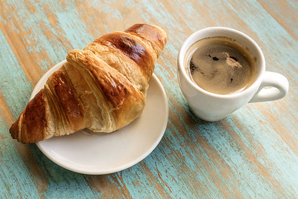 istock Cup of dark coffee with croissant, on wooden table 637854484