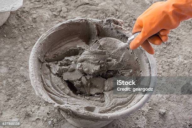 Hand Mit Kelle Und Eimer Mit Mörtel An Der Baustelle Stockfoto und mehr Bilder von Zement