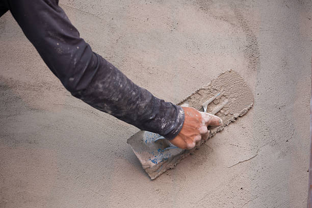 istock hand of worker use trowel plastering concrete at wall 637855540