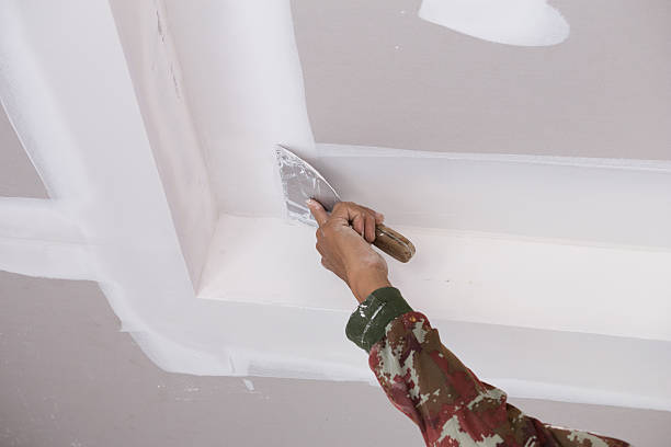 hand of worker using gypsum plaster ceiling joints - plaster plasterer wall repairing imagens e fotografias de stock
