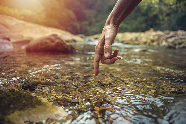 istock Finger touches surface of mountain river 637855872