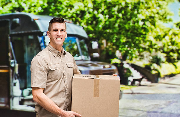 istock Smiling worker holding box outdoors 637856104