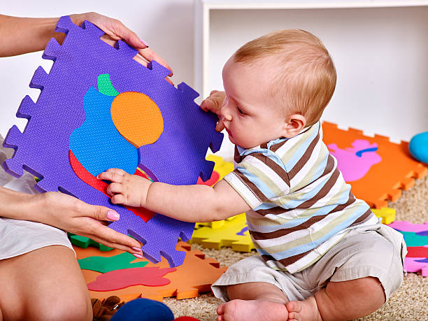 Family puzzle making mother and baby. Child jigsaw develops children. stock photo