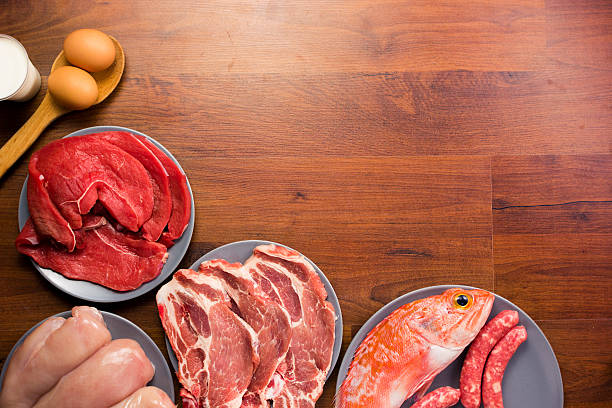 Different types of healthy uncooked proteins on a wooden table stock photo