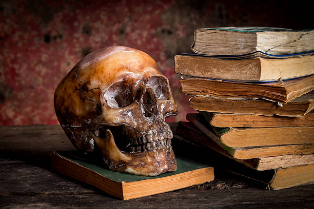 istock Still Life with a Skull and book on wooden table 637860722