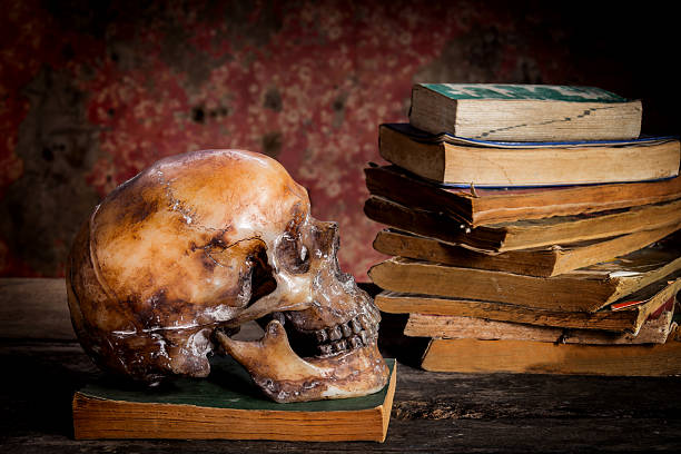 istock Still Life with a Skull and book on wooden table 637860808