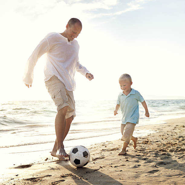 istock Father Son Playing Soccer Beach Summer Concept 637860888