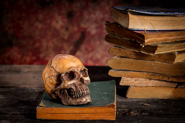 istock Still Life with a Skull and book on wooden table 637860890