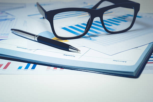 istock Pen and glasses on business graph chart paper with calendar.For 637863994