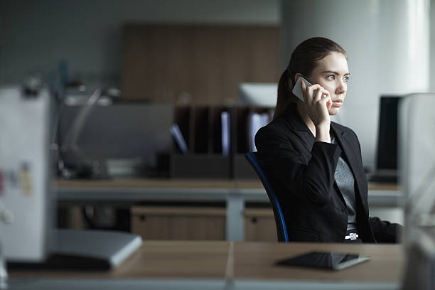 giovane donna che usa il cellulare in ufficio - telephone worried one person discussion foto e immagini stock