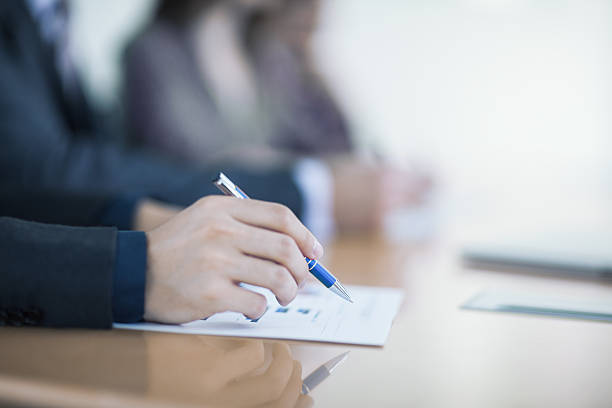 istock View of hand writing on document in business meeting 637866894