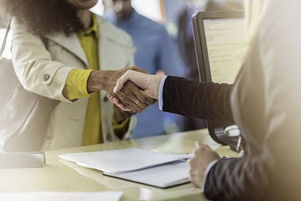 istock Customer and bank teller shaking hands 637866902